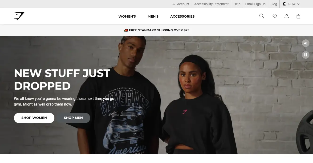 Two models wearing athletic apparel stand against a gray brick wall. Text reads, "New stuff just dropped." Gymshark logo is visible.